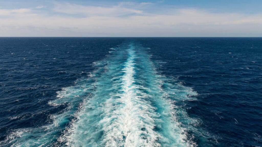 View of an ocean with a white water wake left behind, symbolizing customer churn and the ongoing challenge of retention for tech companies.